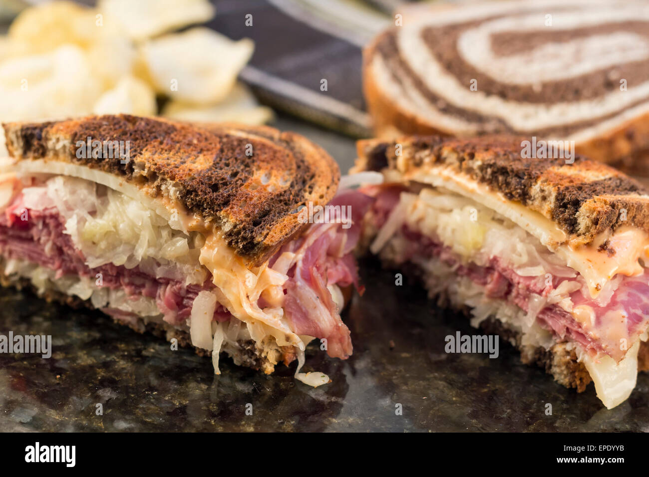 Classic reuben sandwich on pumpernickel swirl rye bread. A hearty meal with a side of pickle and