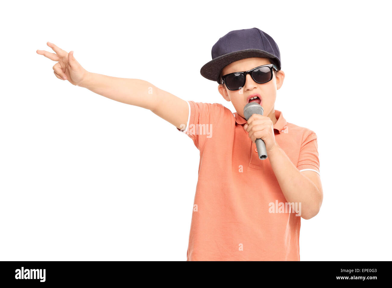 Little boy in hip hop outfit rapping on a microphone and gesturing with his hand isolated on white background Stock Photo
