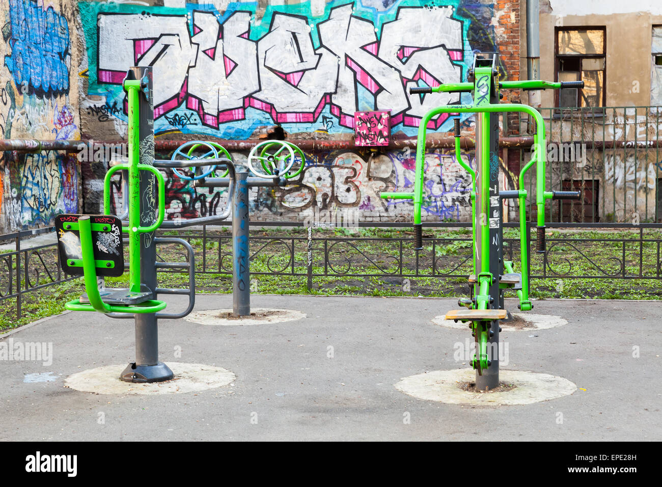Saint-Petersburg, Russia - May 6, 2015: playground with outdoor fitness equipment and chaotic graffiti on old urban walls Stock Photo