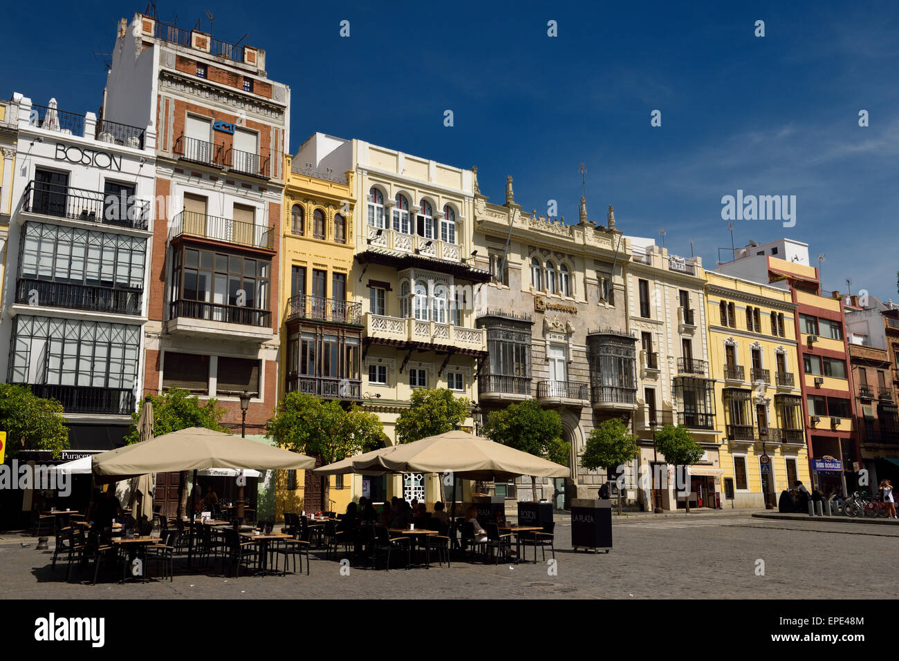 Outdoor patio with tourists and varied architectural styles in Plaza de San Francisco Seville Spain Stock Photo