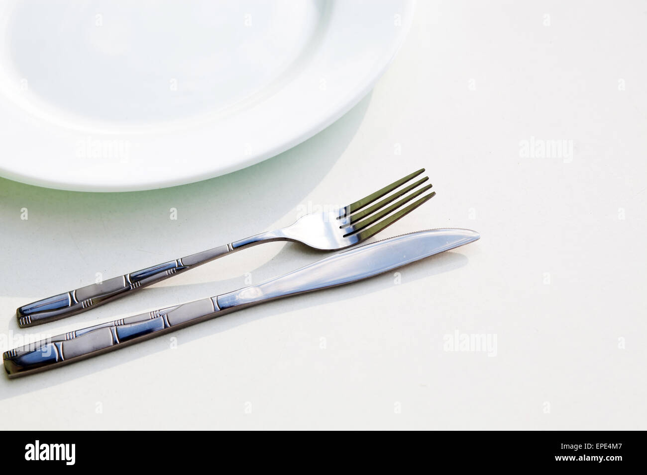 Knife, white plate and fork Stock Photo - Alamy