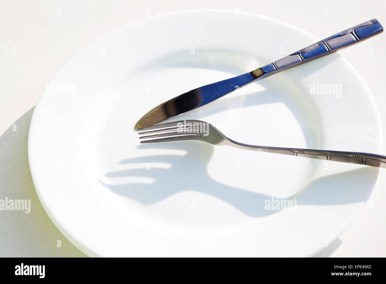 Knife, white plate and fork Stock Photo - Alamy