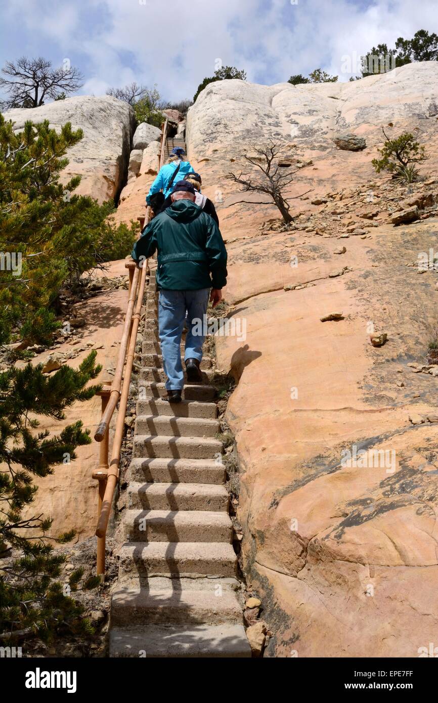 Sibling and a friend climbing steps up sandstone bluff New Mexico - USA Stock Photo