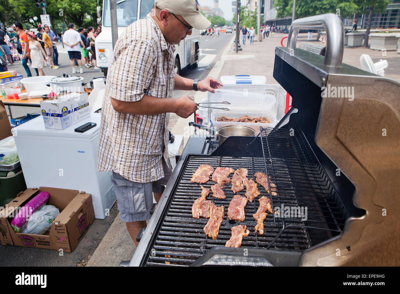 Man grilling Korean short ribs (Kalbi) at an outdoor event - USA Stock Photo