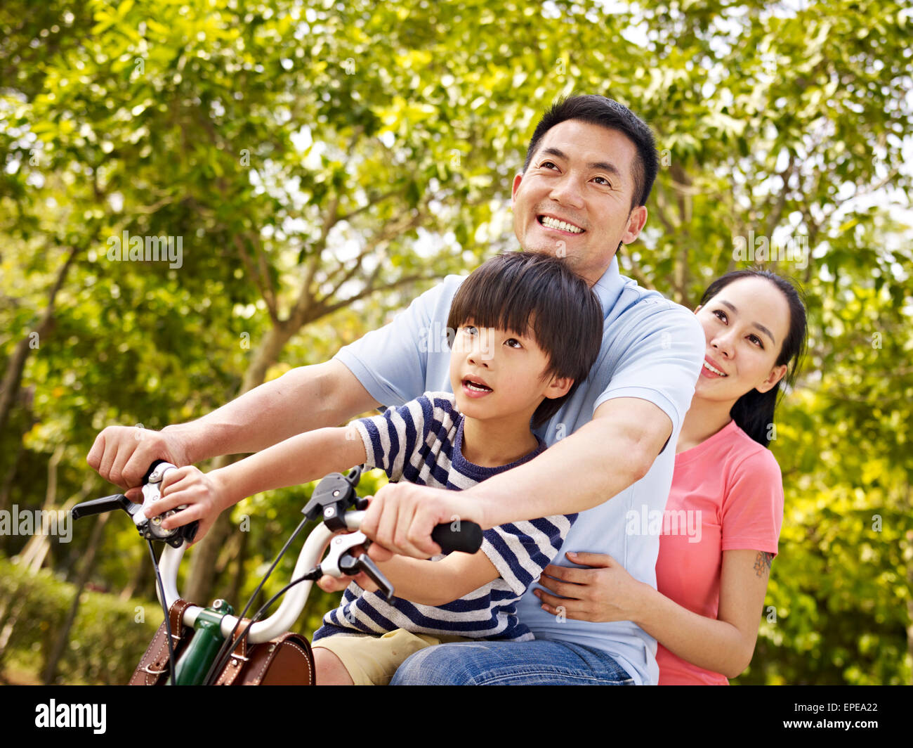 asian family riding bike outdoors Stock Photo