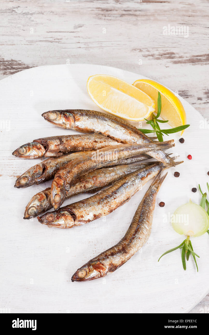 Culinary seafood eating. Grilled sardines on wooden background with