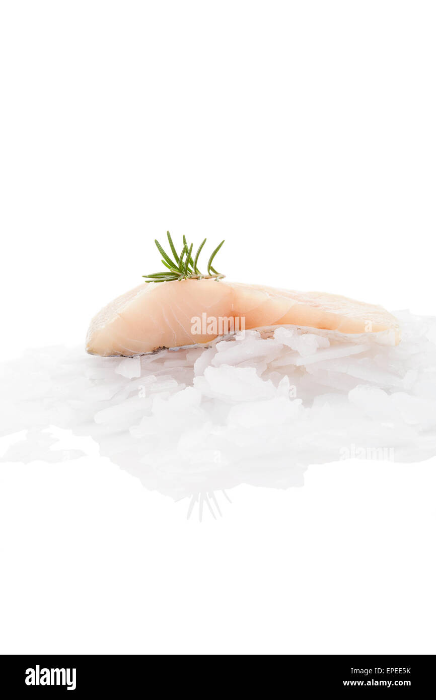 Fish fillet with fresh rosemary on ice isolated on white background. Delicious culinary fish fillet eating. Perch fish. Stock Photo