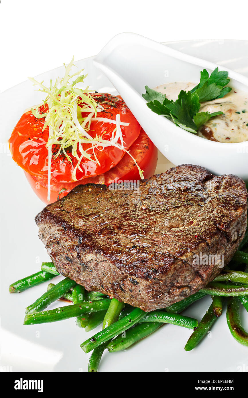 Grilled beef steak with vegetable garnish. Hearty steak dinner. Stock Photo