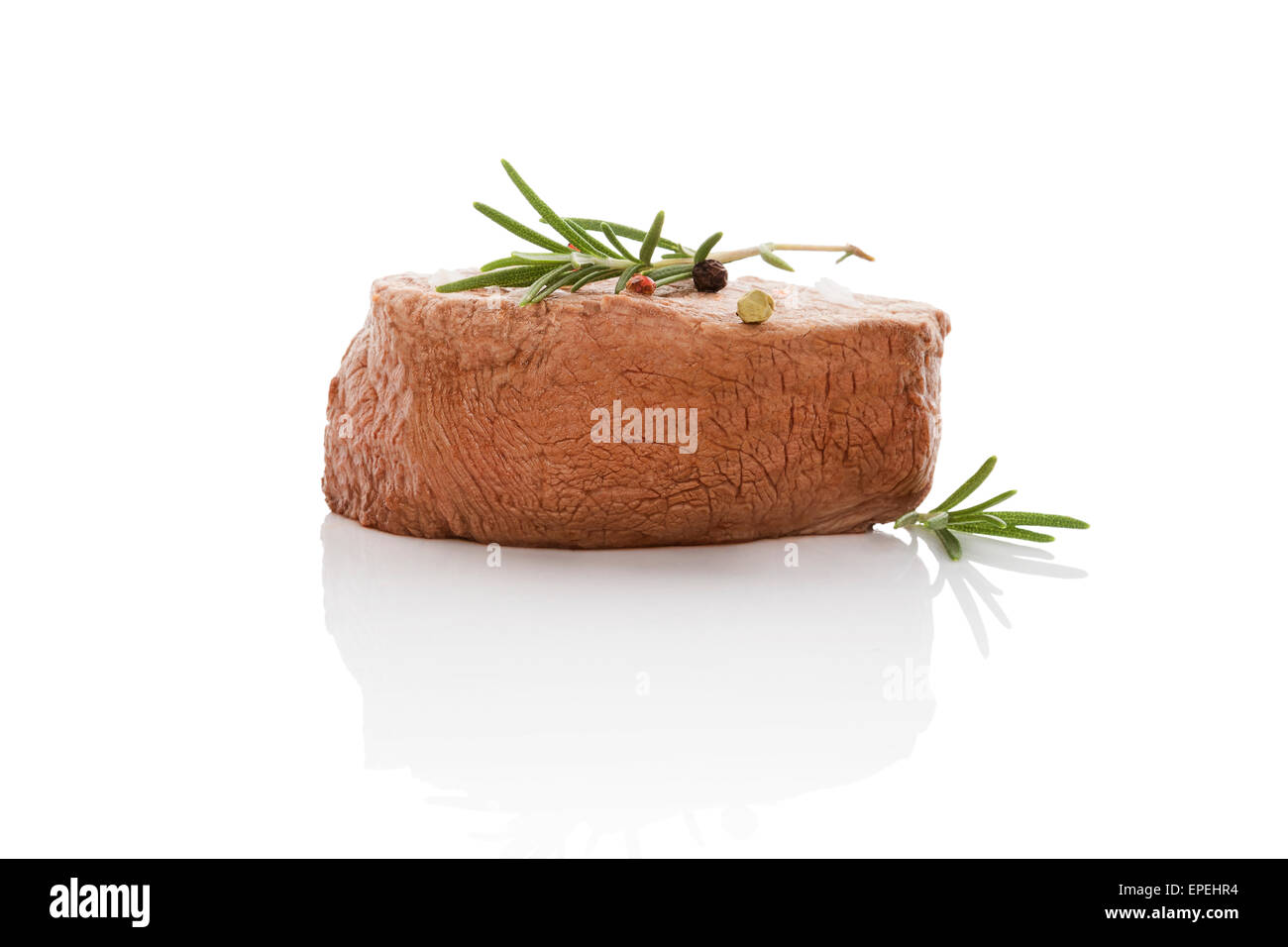 Luxurious grilled big steak with fresh rosemary herb isolated on white background. Culinary beefsteak eating. Paleo diet. Stock Photo