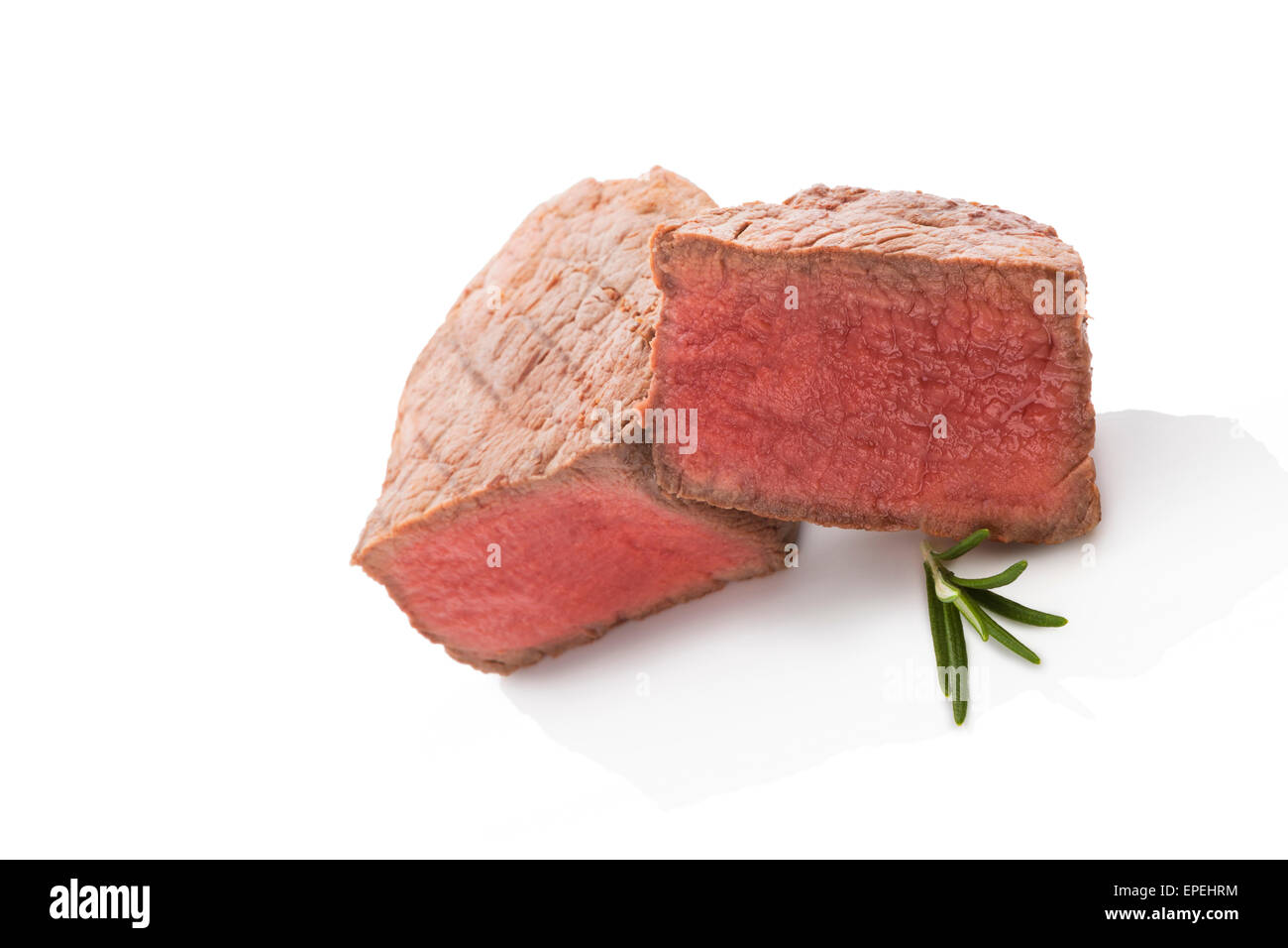 Big tenderloin steak with fresh herbs isolated on white background