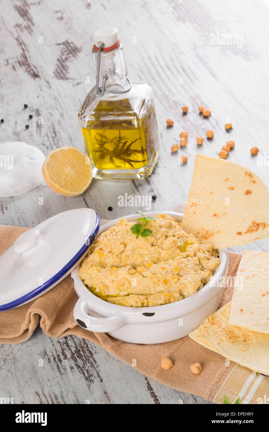 Olive oil, hummus, chickpeas and pepper corns isolated on white background. Culinary mediterranean cuisine. Stock Photo