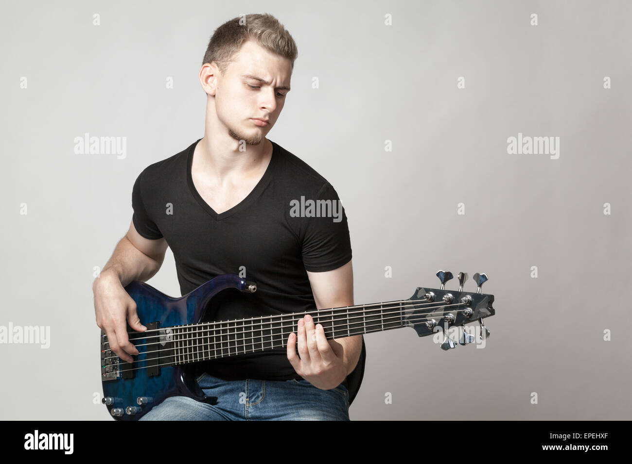 male musician playing a sixstring bass guitar Stock Photo Alamy