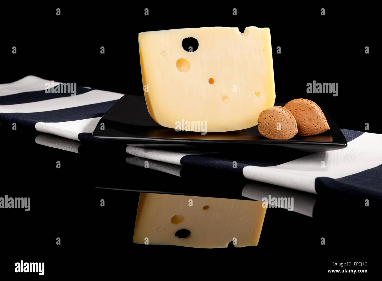 Emmental cheese still life. Emmental piece with almond nuts isolated on
