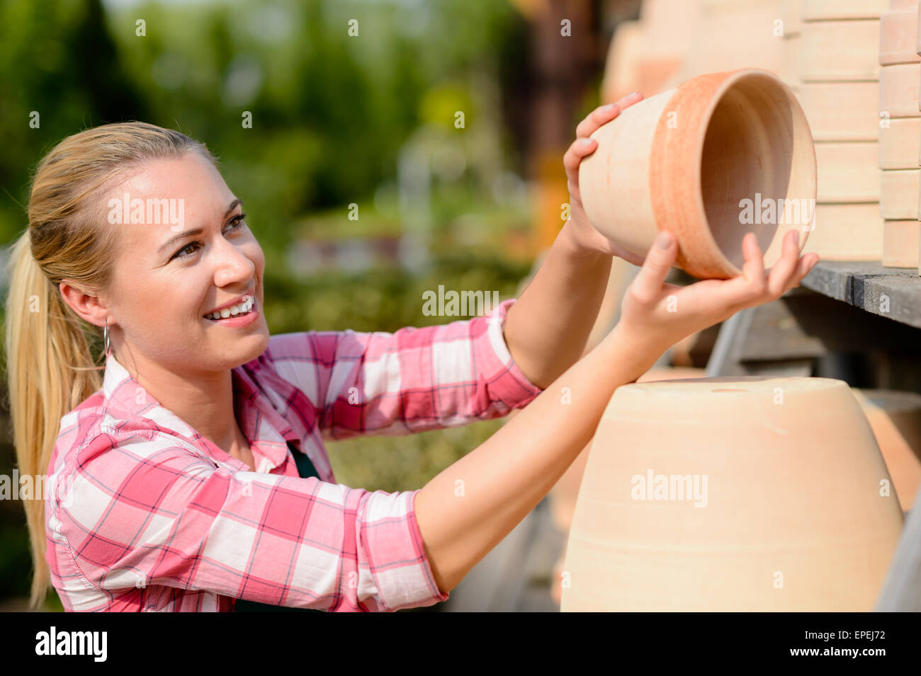 Garden center woman putting clay pots shelf Stock Photo Alamy