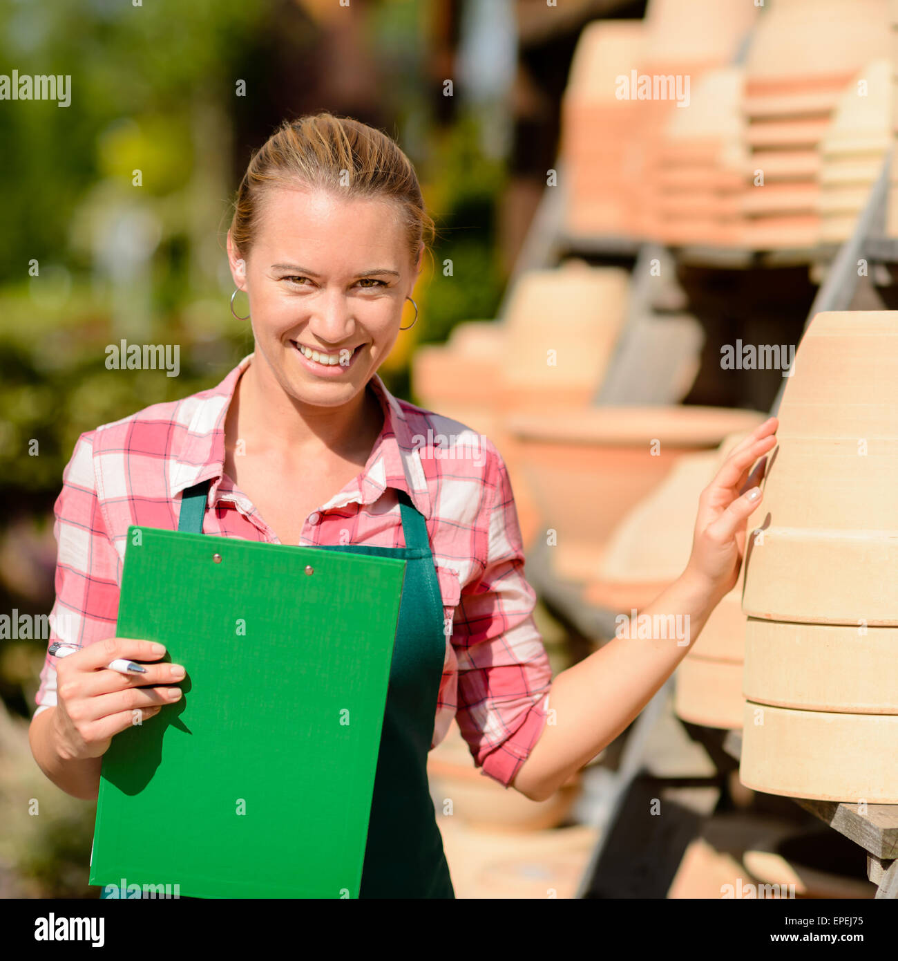 Garden center woman by clay pots shelf Stock Photo