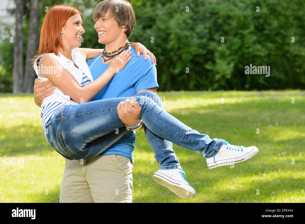 Teenage boyfriend carry girlfriend in his arms Stock Photo Alamy