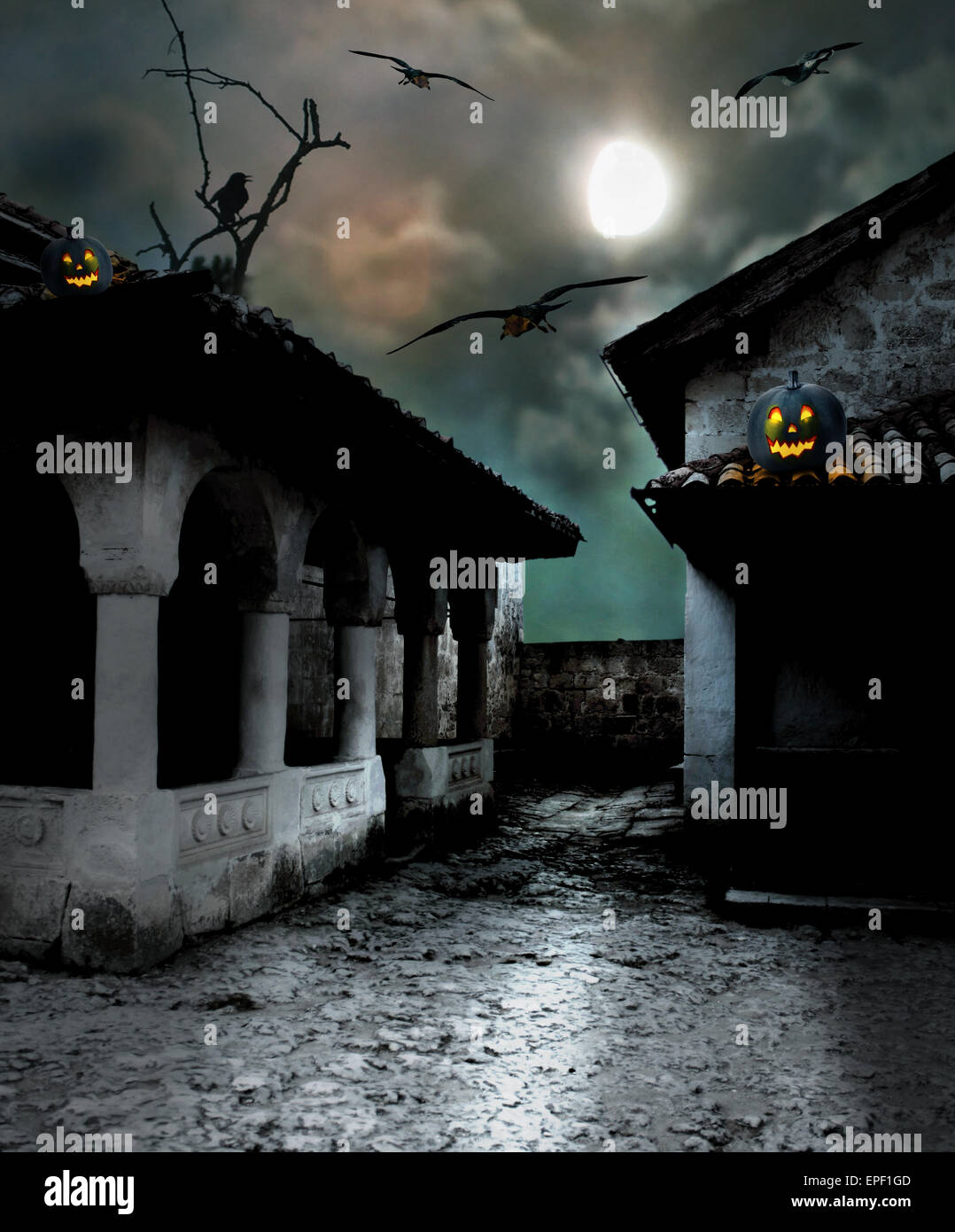 Halloween pumpkins in the yard of an old house at night in the bright moonlight Stock Photo