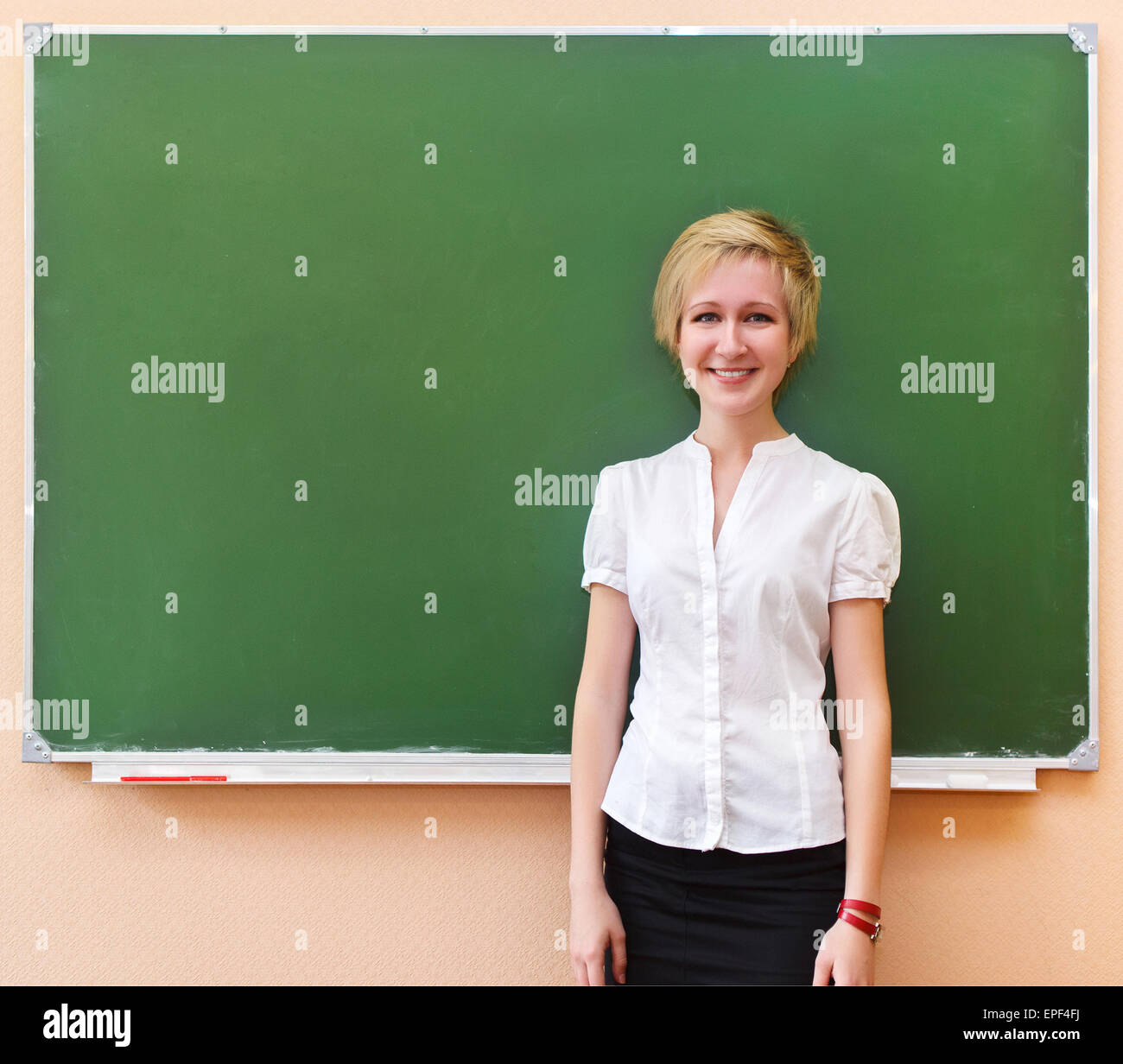 Student girl standing near blackboard in the classroom Stock Photo - Alamy
