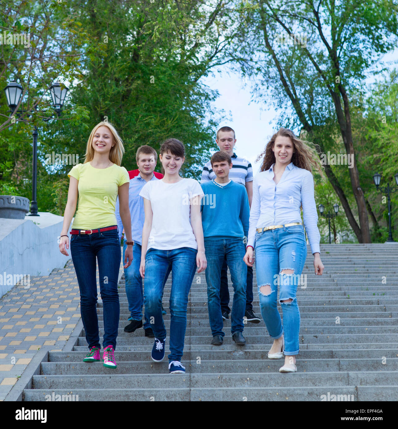 Group of smiling teenagers walking outdoors Stock Photo