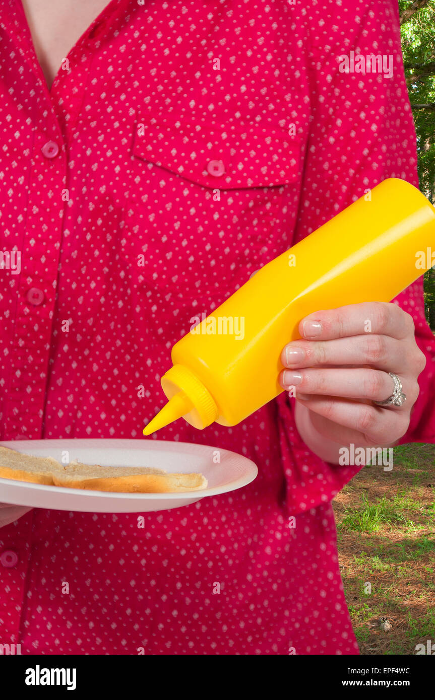 Woman Squeezing Mustard Stock Photo