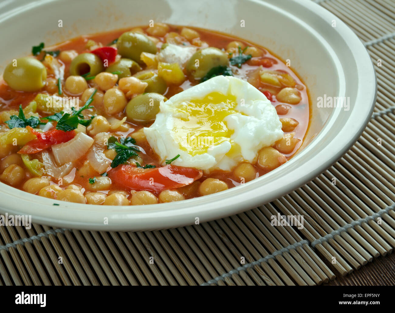 Lablabi - Tunisian dish based on chick peas. Raw or soft-cooked egg ,mix  along with olive oil, harissa,  and sometimes olives,  Stock Photo
