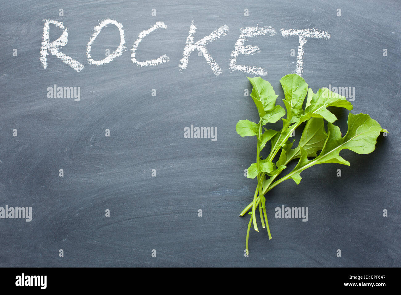 fresh rocket leaves on chalkboard Stock Photo