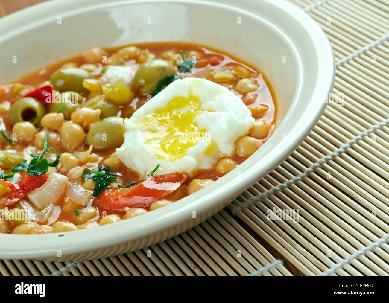 Lablabi - Tunisian dish based on chick peas. Raw or soft-cooked egg ,mix  along with olive oil, harissa,  and sometimes olives,  Stock Photo