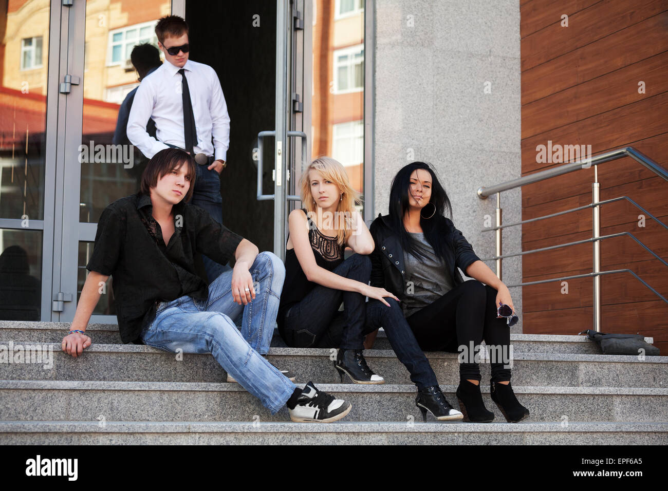 Young people sitting on the steps Stock Photo - Alamy