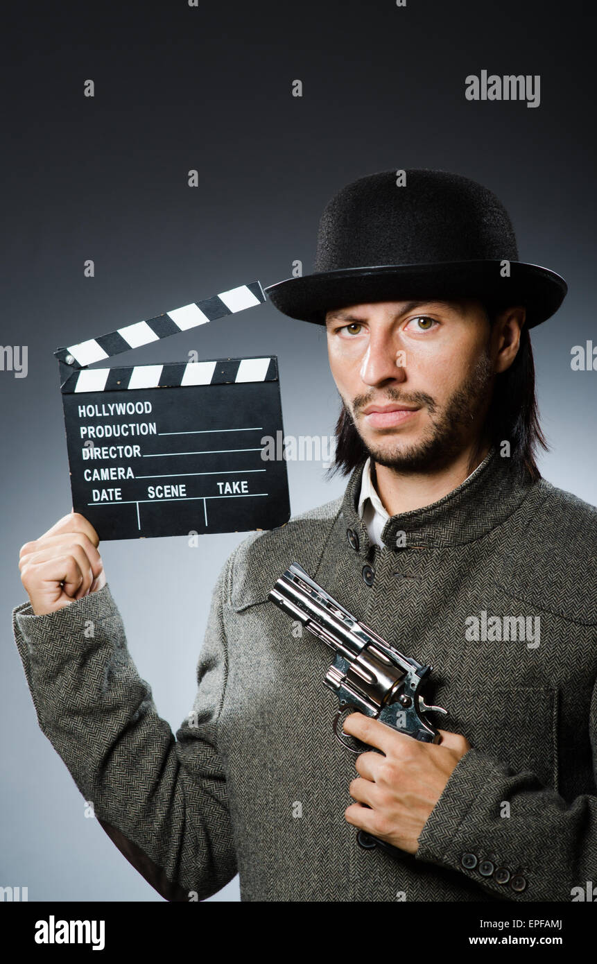 Man with gun and movie clapboard Stock Photo - Alamy