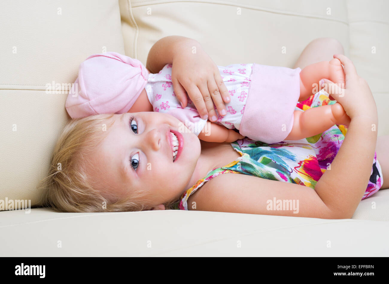 Little smiling girl with doll Stock Photo