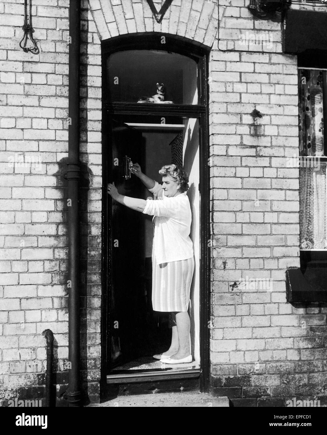 Elsie Starkey, mother of Ringo Starr, July 1964. Pictured polishing door knocker at No. 10 Admiral Grove, Liverpool.  A.k.a. Elsie Gleave Elsie Grave Stock Photo