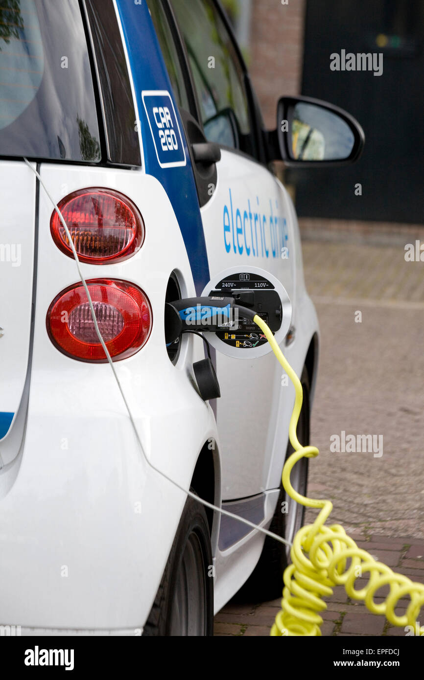 Electric car charging from an on-street Electric charge station Stock Photo