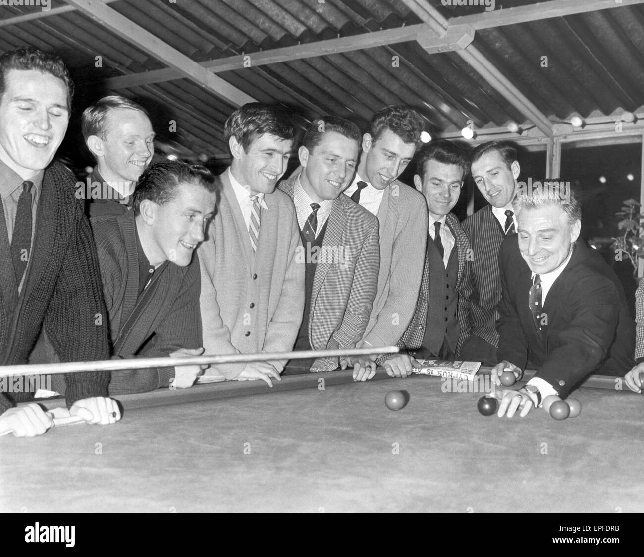 Southampton FC players and manager at Ocean Hotel, Brighton, Monday 30th December 1963. Manager, Ted Bates, talkes tactics with billiard balls. The players are T Paine, T Traynor, J Sydmean, T Godfrey, M Chivers, C Auxford, R Davies, the manager Ted Bates Stock Photo