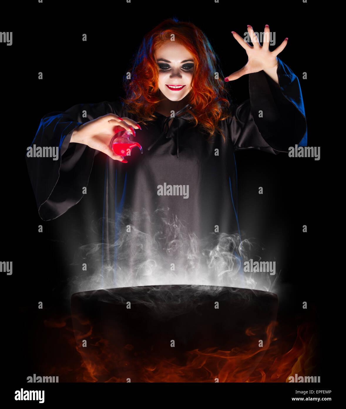 Young witch with red potion isolated Stock Photo