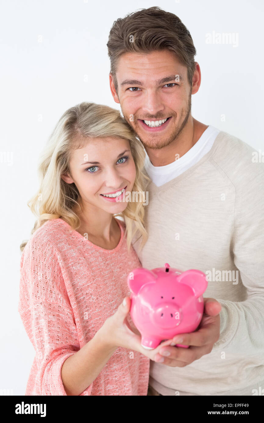 Attractive young couple holding piggybank Stock Photo - Alamy