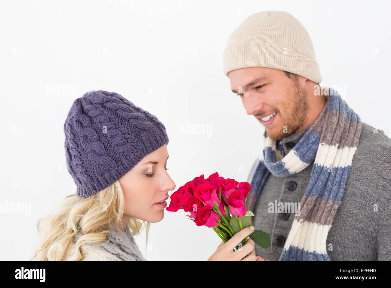 Attractive couple in warm clothing holding flowers Stock Photo