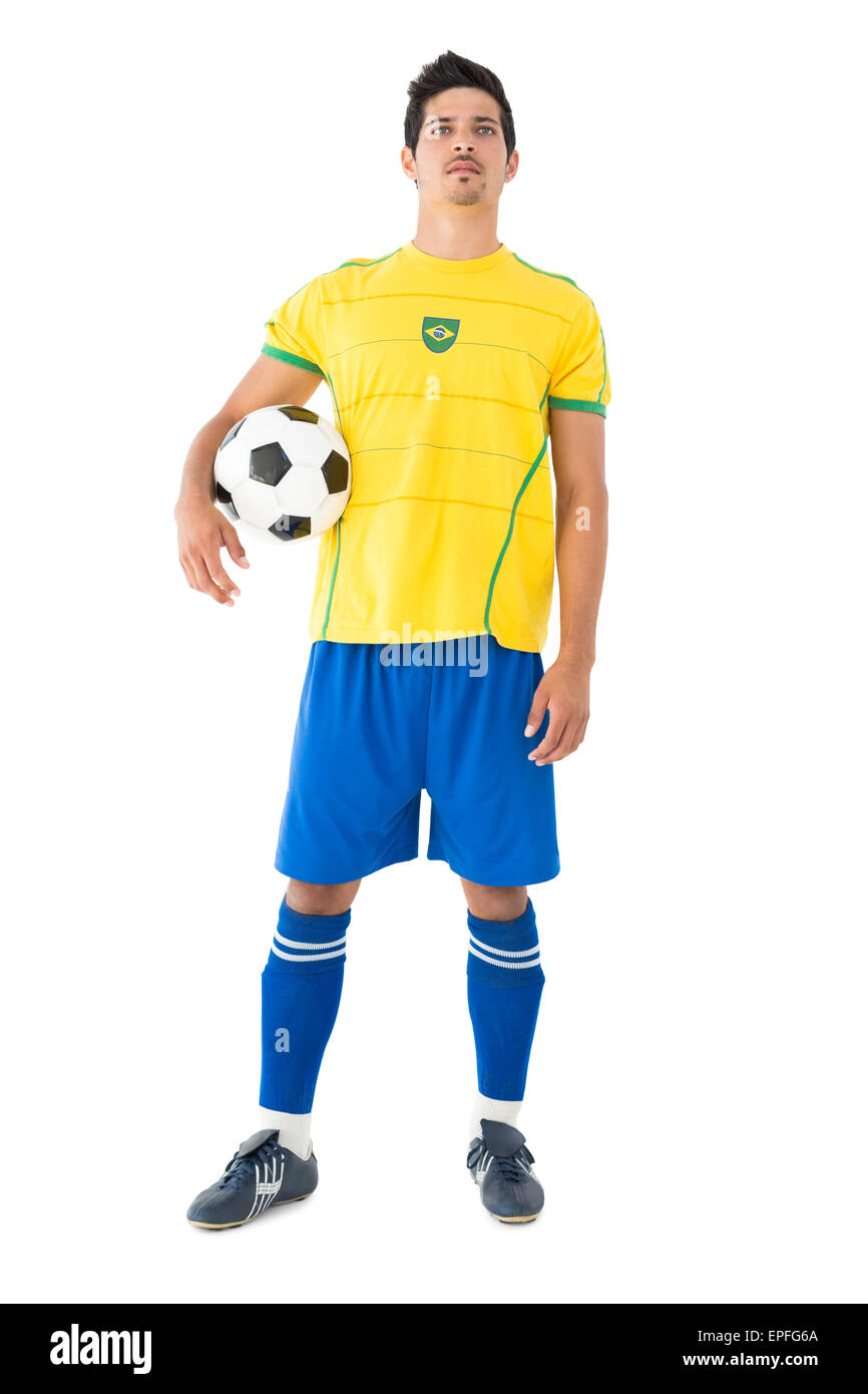 Attractive latin man in a yellow brazilian soccer jersey standing with  crossed arms on an isolated white background Stock Photo - Alamy