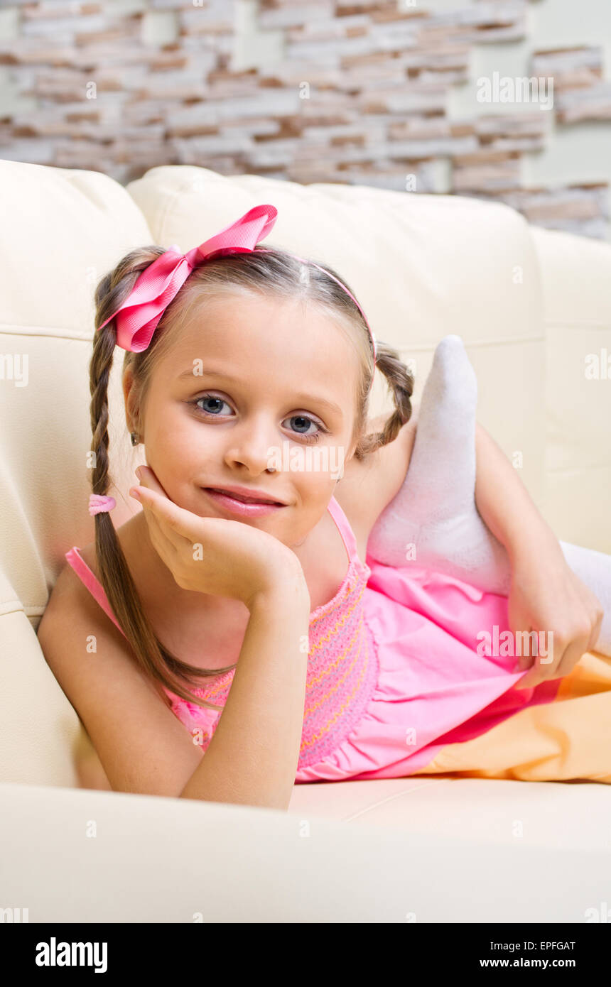 Little girl in pink dress on sofa Stock Photo Alamy
