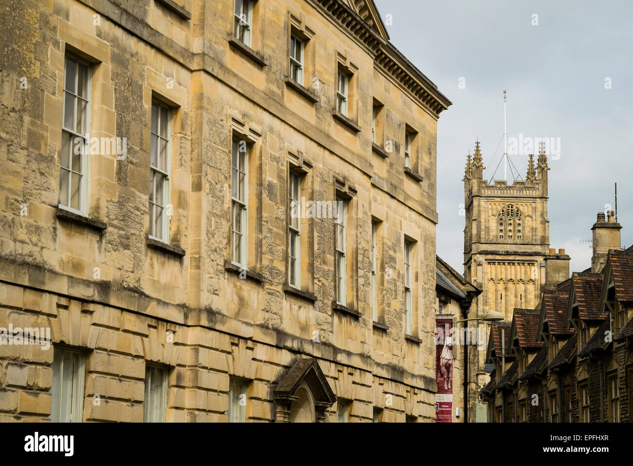 Typical cotswold stone buildings leading to the tower of the Parish Church of St John Baptist , a 'wool church' in Cirencester, Gloucestershire, England UK Stock Photo