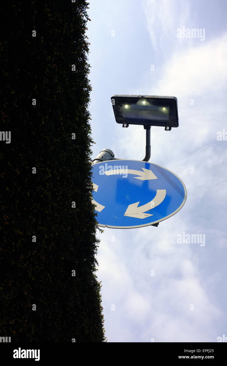 A roundabout sign half obscured by a hedge in the Clifton area of Bristol. Stock Photo