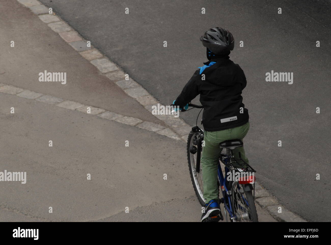 Child riding a bike in a city street. Stock Photo