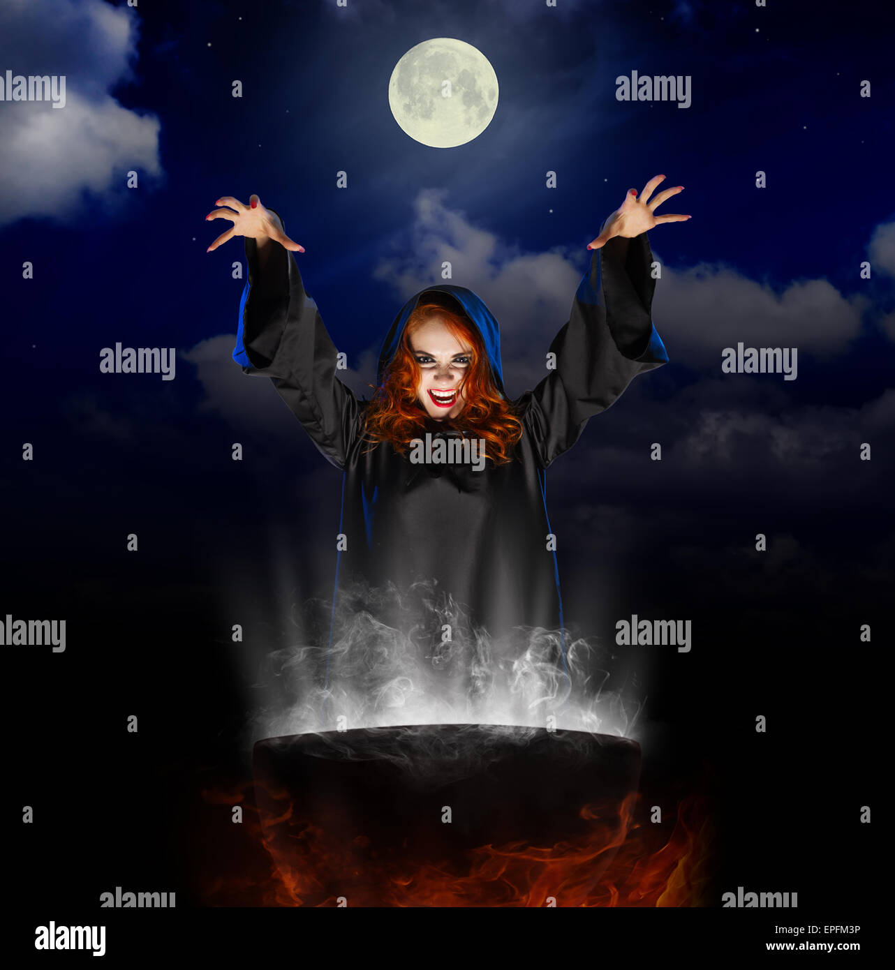 Young witch with cauldron on night sky background Stock Photo