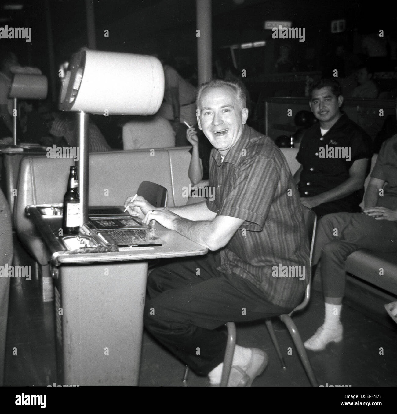 1950s, historical, man sitting at desk playing bingo or lottery shows his delight at winning, USA. Stock Photo