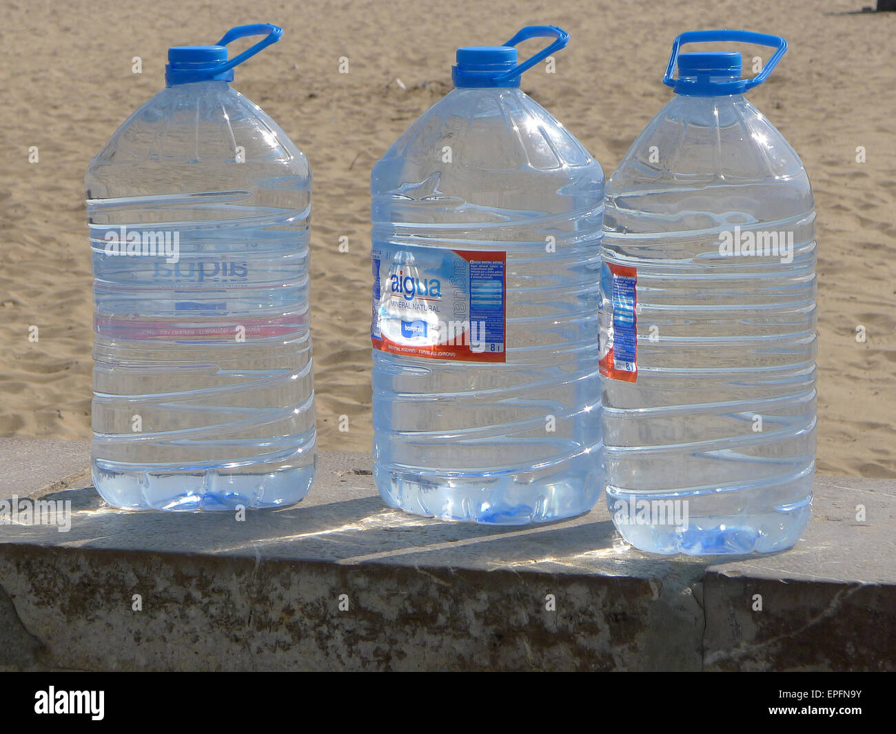 Large 5 Litre Drinking Water Containers On Wall Next To Beach Stock 