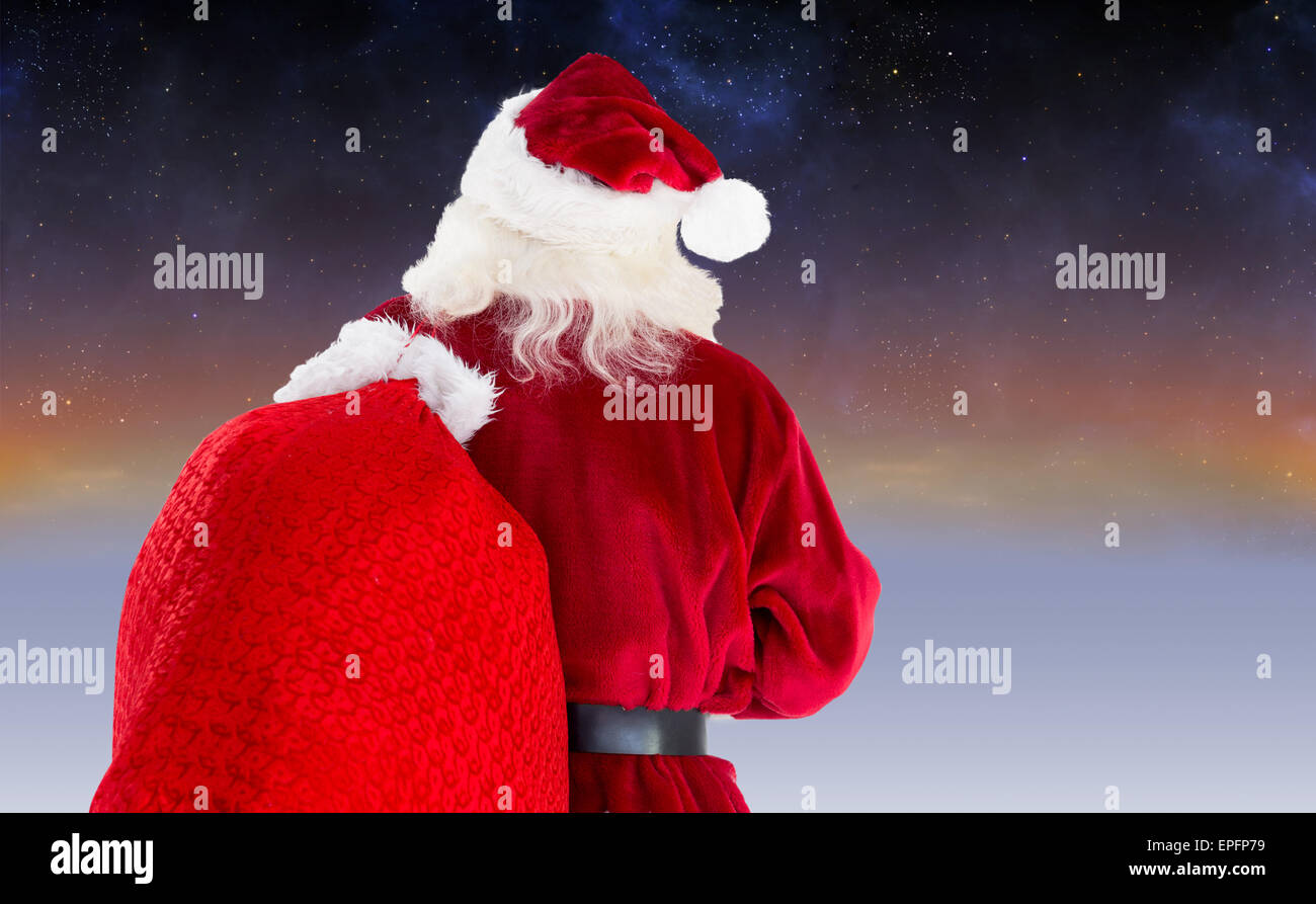Composite image of santa claus carrying sack Stock Photo - Alamy