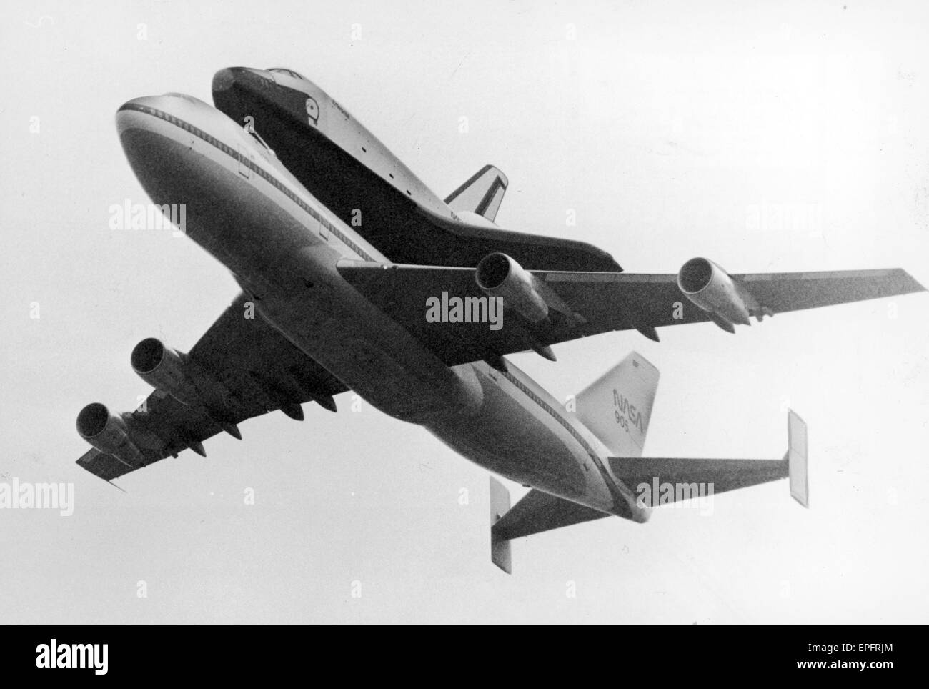 Space Shuttle Enterprise, piggy back on a NASA 747 Jumbo Jet, flies over Manchester Airport at 11 o'clock, sweeping in from Heard Green Area at 600ft. After a slow glide down the route of the runway, the shuttle slowly climbed up to 1000ft and was gone in Stock Photo