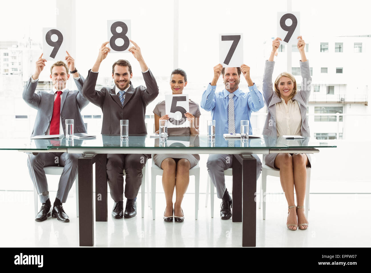 Interview panel holding score cards in office Stock Photo Alamy