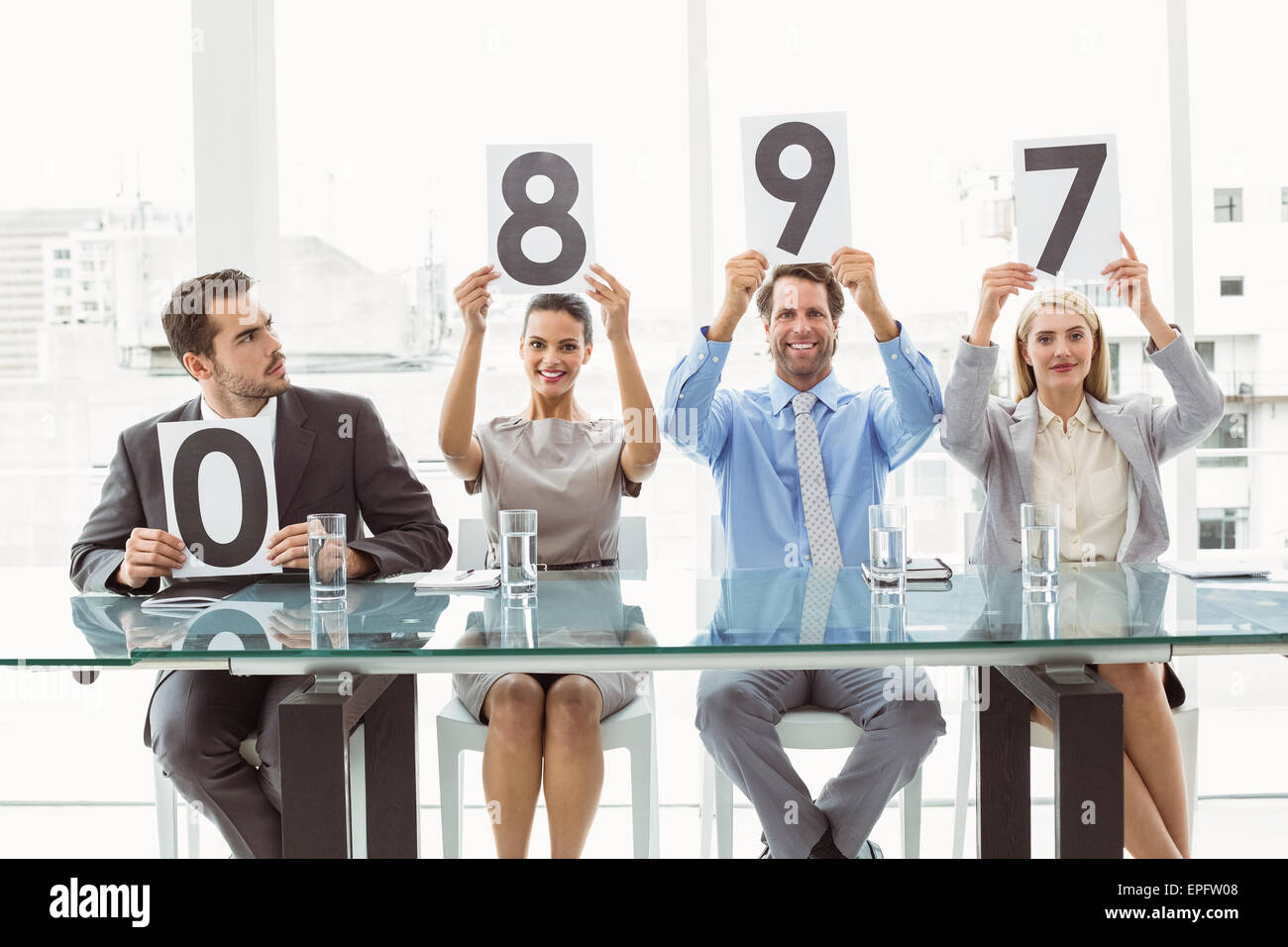 Interview panel holding score cards in office Stock Photo Alamy