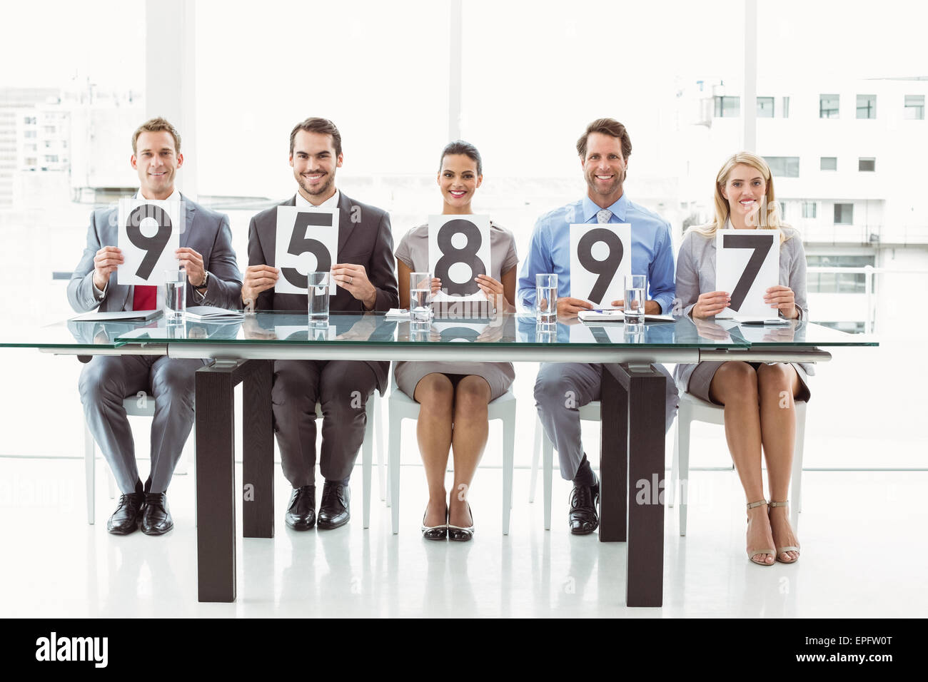 Interview panel holding score cards in office Stock Photo - Alamy