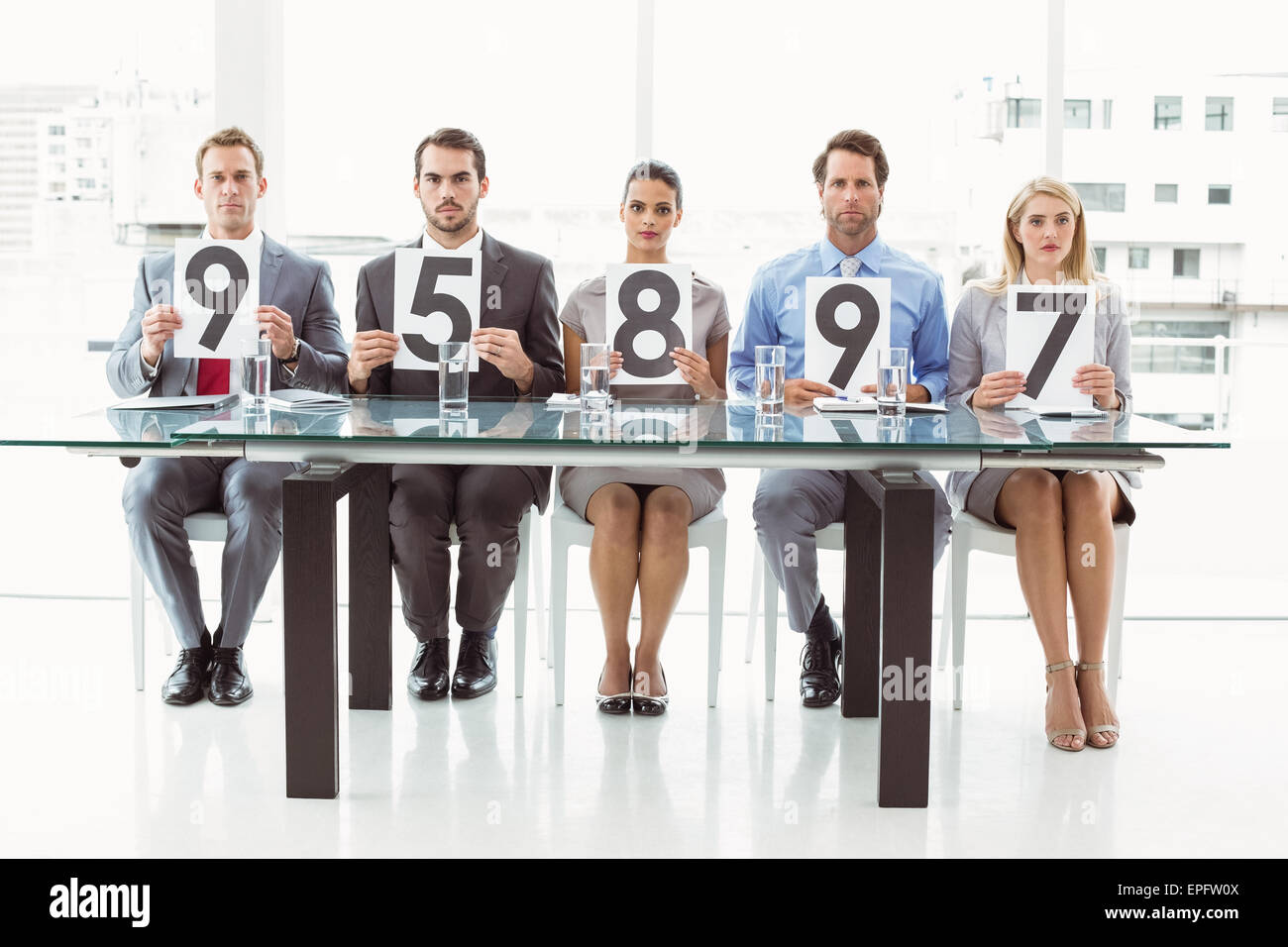 Interview panel holding score cards in office Stock Photo Alamy
